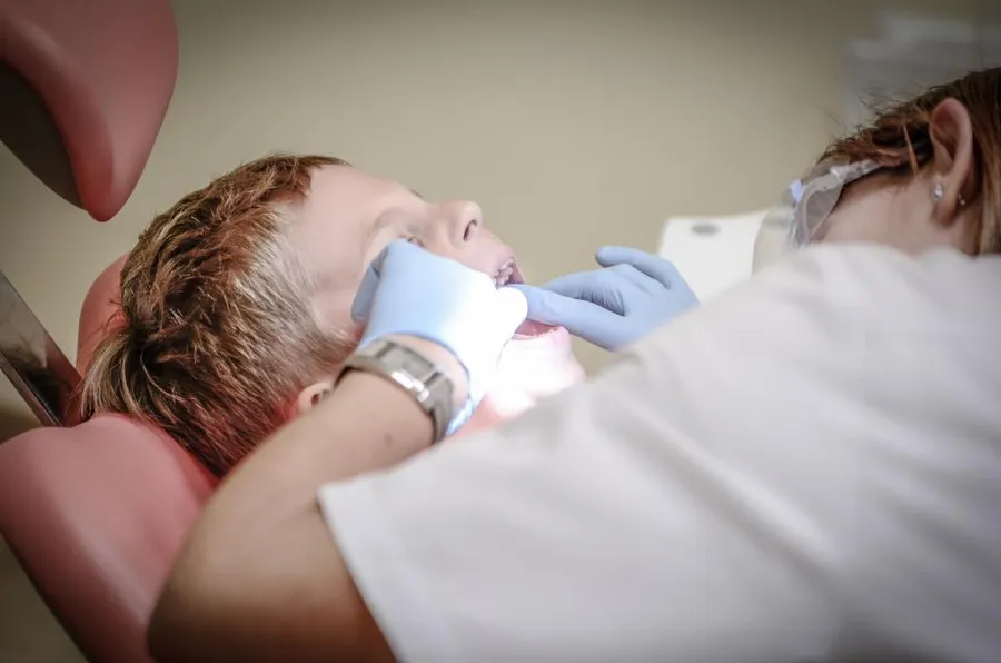 Dentist examining a young patient in a dental chair